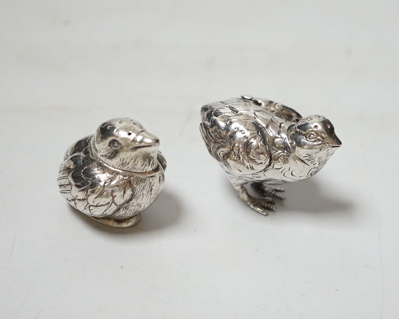 Two novelty silver pepperettes, modelled as chicks, the smallest with import marks for London, 1925, the other with import marks, but no date letter.